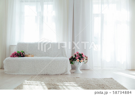 sofa with flowers in the interior of the white room of the house sofa with flowers in the interior of the white room of the house 58734884