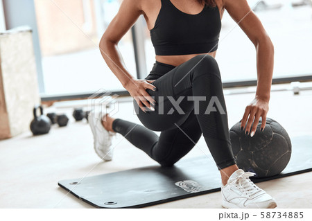 young femaleathlete stretching muscle legs in gym young femaleathlete stretching muscle legs in gym 58734885