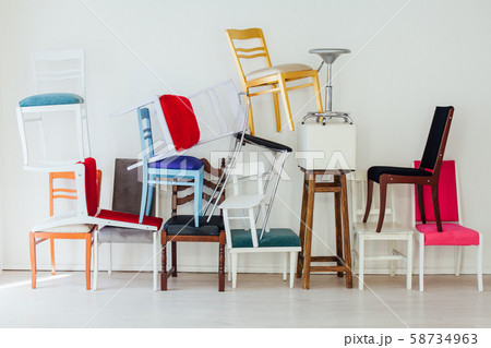 lots of different chairs in the interior of an empty white room 58734963