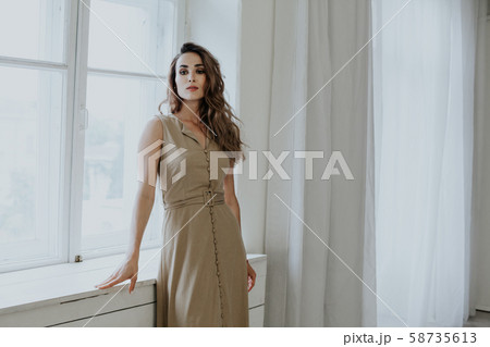 beautiful fashionable woman in beige dress in empty room beautiful fashionable woman in beige dress in empty room 58735613