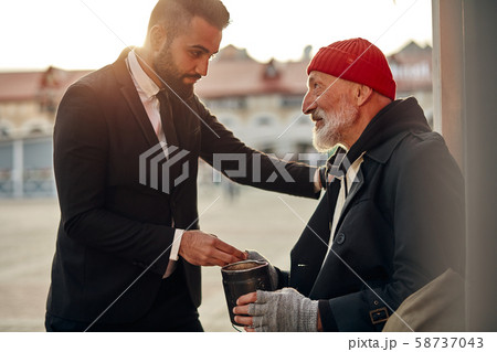 Rich man help senior beggar 58737043