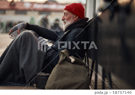 homeless person waiting help. Unemployed beggars live on street 58737140