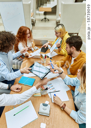 Hardworking designers brainstorming at tables 58739049