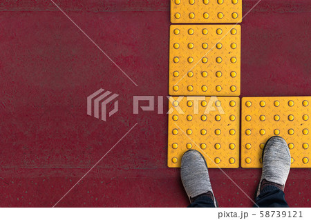 shoes on rough yellow dot tactile paving for blind handicap on tiles pathway in japan shoes on rough yellow dot tactile paving for blind handicap on tiles pathway in japan 58739121