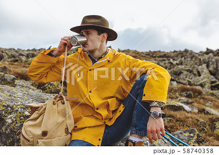 young stylish traveller enjoying drinking hor tea young stylish traveller enjoying drinking hor tea 58740358