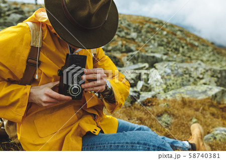 tired tourist sitting on the mountain and taking a photo 58740381