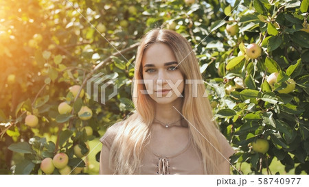 Portrait of a young beautiful seventeen-year-old blonde girl in the apple orchard. Portrait of a young beautiful seventeen-year-old blonde girl in the apple orchard. 58740977