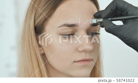 Create permanent eyebrow makeup. Marking the shape of the eyebrows. Create permanent eyebrow makeup. Marking the shape of the eyebrows. 58741022