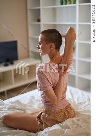 Close-up photo of woman on bed, arms behind back 58741023