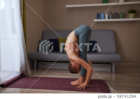 Young caucasian yogi at home doing practice yoga or fitness Young caucasian yogi at home doing practice yoga or fitness 58741264