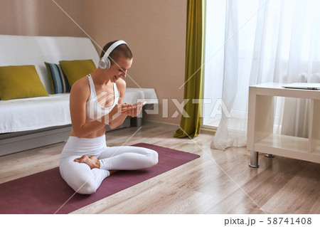 Portrait of sporty short-haired girl doing yoga exercises at home. Portrait of sporty short-haired girl doing yoga exercises at home. 58741408