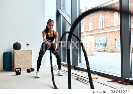 Young girl battling ropes in gym Young girl battling ropes in gym 58742074