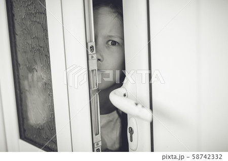 Scared girl kid in opened door. Safety concept Scared girl kid in opened door. Safety concept 58742332