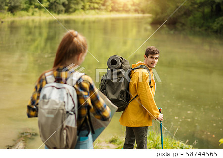 young blonde hiker looking back while standing near the lake young blonde hiker looking back while standing near the lake 58744565