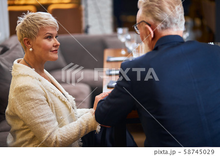 Elderly modern friends in restaurant speaking 58745029