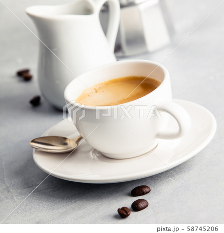 Coffee espresso in white cup with milk and coffee maker Coffee espresso in white cup with milk and coffee maker 58745206