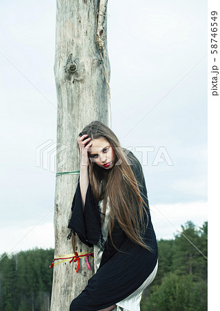 fashion style dressed girl with dreamcatcher outside in field, making witchcraft ritual at halloween 58746549