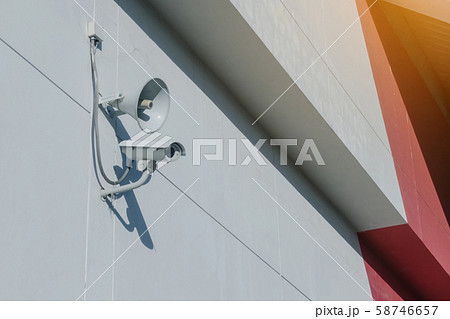 Loudspeakers and CCTV security cameras observation on a wall of a building 58746657