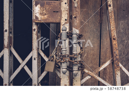 The front view old gold steel lock and damaged and rusted steel door on wooden door background 58748738