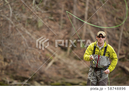 Young man fly-fishing Young man fly-fishing 58748896