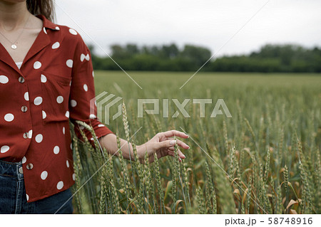 Woman wearing red polka dot shirt in wheat field Woman wearing red polka dot shirt in wheat field 58748916