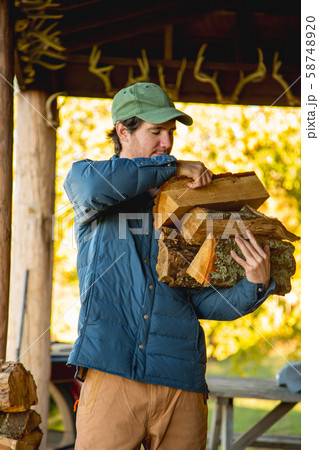 Young man holding firewood Young man holding firewood 58748920