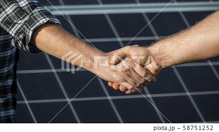 Handshake of two businessmen on a background surface of solar panels Handshake of two businessmen on a background surface of solar panels 58751252