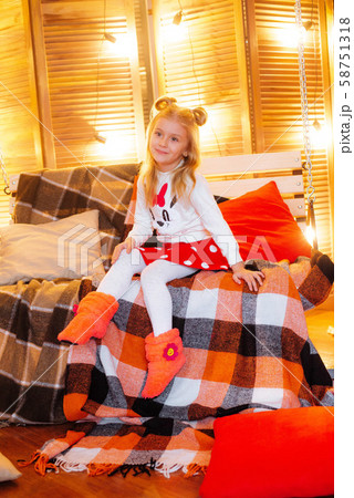 Cute girl of school age with blond  hair in an autumn studio with yellow leaves, plaids, pumpkins and apples 58751318