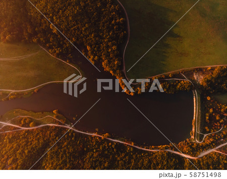 Aerial view of lake, dam, forest and warm sunset or sunrise. Top view Aerial view of lake, dam, forest and warm sunset or sunrise. Top view 58751498