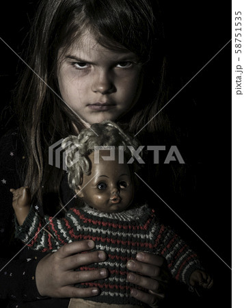 Creepy young girl with scary doll 58751535