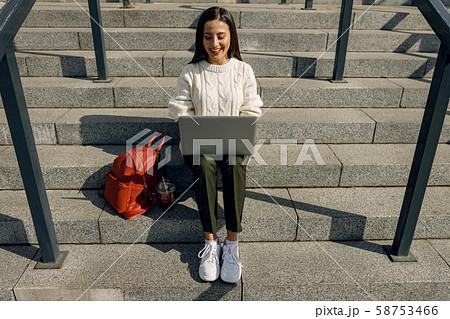 Cheerful freelancer working outdoors in the city center Cheerful freelancer working outdoors in the city center 58753466