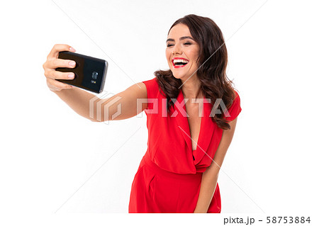 A young woman with red lips, bright makeup, a dazzling smile, dark wavy long hair, in a red summer A young woman with red lips, bright makeup, a dazzling smile, dark wavy long hair, in a red summer 58753884