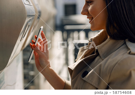 Positive delighted girl holding smartphone in right hand 58754608