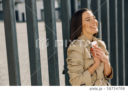 Positive delighted brunette female embracing her smartphone 58754709