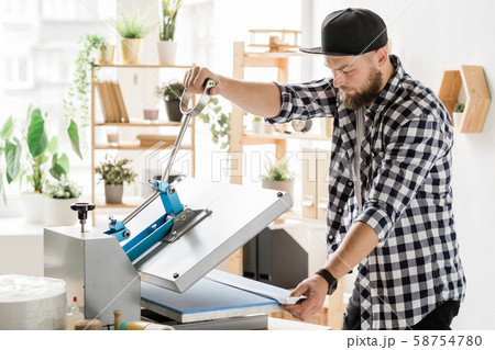 Craftsman using special equipment while printing decor on workpiece of collar Craftsman using special equipment while printing decor on workpiece of collar 58754780