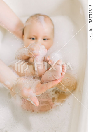Happy little baby a swimming in the bathroom.Portrait of baby bathing in a bath with foam 58759812