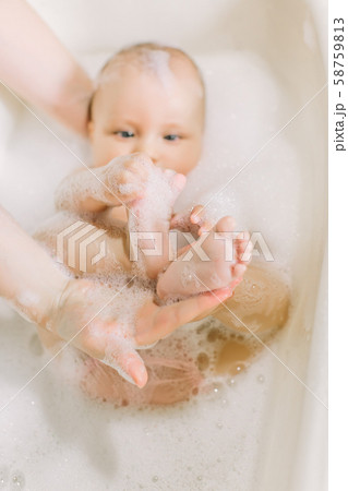 Happy little baby a swimming in the bathroom.Portrait of baby bathing in a bath with foam 58759813