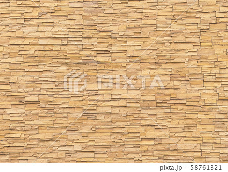 Rock stone brick tile wall aged texture detailed pattern background in light yellow cream brown color Rock stone brick tile wall aged texture detailed pattern background in light yellow cream brown color 58761321