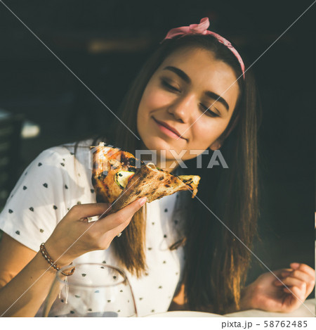 Happy caucasian woman eating pizza and drinking 58762485