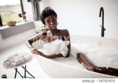Beautiful dark-eyed woman lying in bath with foam 58762933