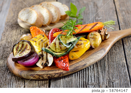 Vegan cuisine: Mixed grilled vegetables on a wooden cutting board served with Italian ciabatta bread 58764147