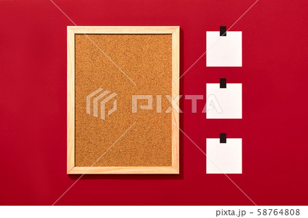 Empty cork board with blank notes on red background 58764808