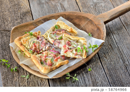 Tarte Flambee from Alsace with onions and bacon, similar to a pizza, thin dough with sour cream 58764966
