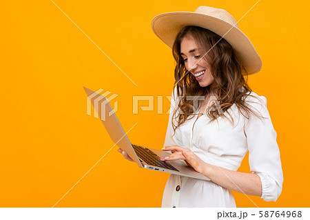 half-length shot of a girl with a laptop in hands, orange isolated background 58764968