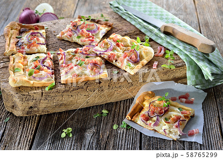 Tarte flambee from Alsace with onions, bacon and sour cream served Tarte flambee from Alsace with onions, bacon and sour cream served 58765299