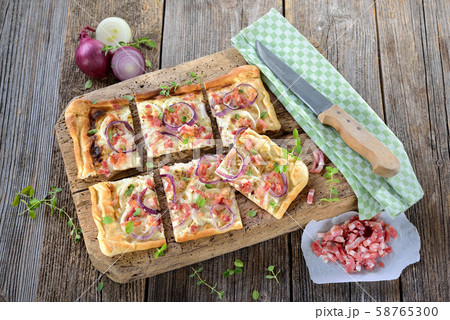 Tarte flambee from Alsace with onions, bacon and sour cream served Tarte flambee from Alsace with onions, bacon and sour cream served 58765300