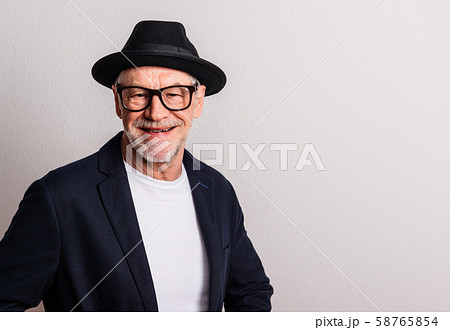 Portrait of a senior man with hat and glasses in a studio. Copy space. Portrait of a senior man with hat and glasses in a studio. Copy space. 58765854