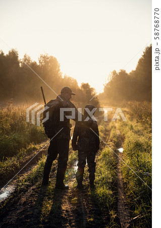 father pointing and guiding son on first deer hunt father pointing and guiding son on first deer hunt 58768770