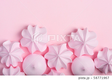 Meringue cookies border. Sweet crispy twisted and drop meringue on pink pastel background with copy-space. 58771967