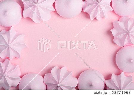 Meringue cookies frame. Sweet crispy twisted and drop meringue border on pink pastel background with copy space. 58771968